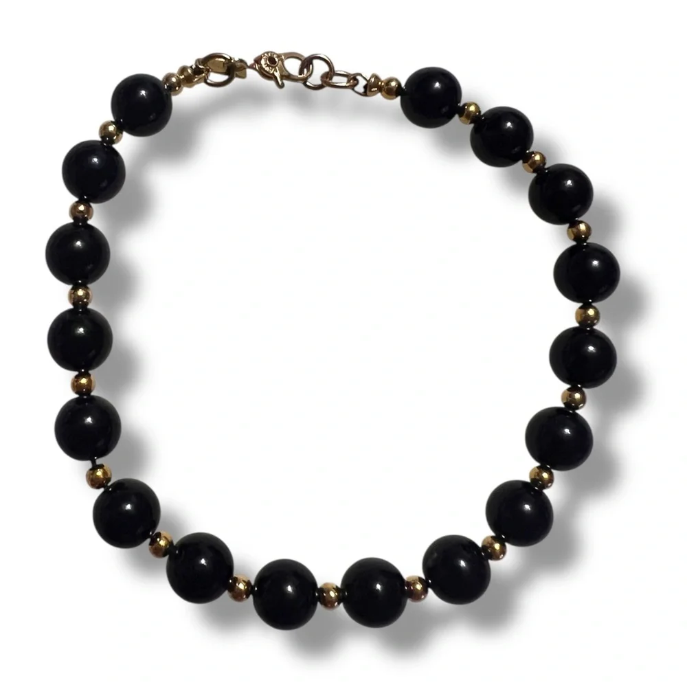Vintage Monet signed black bead and gold tone spacers bracelet. 8”